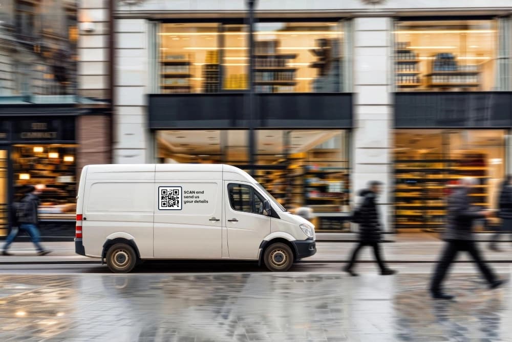 A work van on a city street with a QR code decal on the side panel